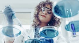 Female scientist in the laboratory working with Petri dishes and a pipette.