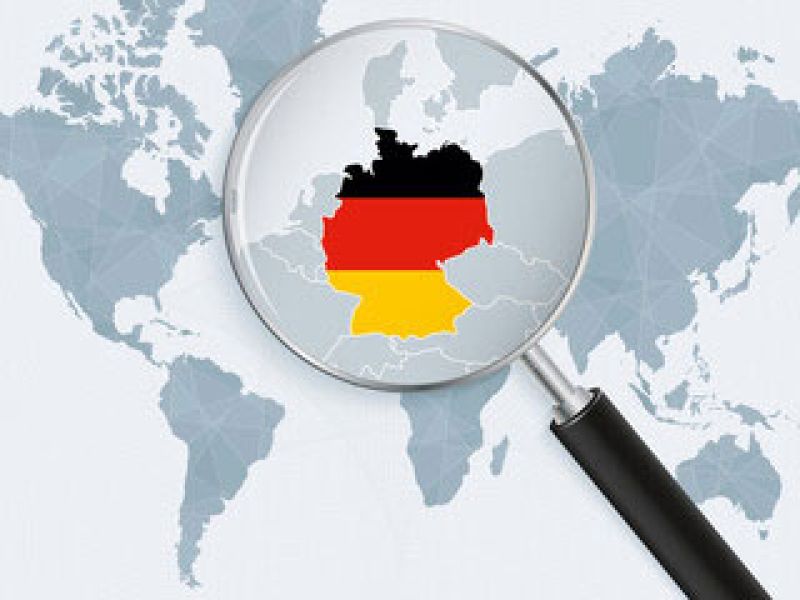 World map with magnified section highlighting Germany under a magnifying glass.